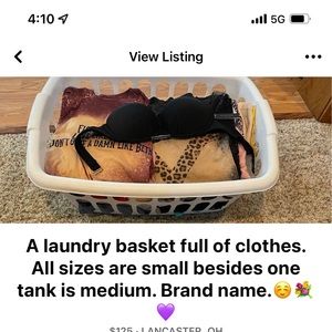 A laundry basket full of clothes. All sizes are small besides one tank is medium